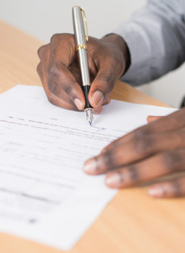 Canva – Person Holding Gray Twist Pen and White Printer Paper on Brown Wooden Table