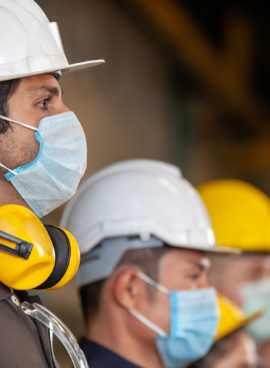 Workers wear protective face masks for safety in machine industrial factory.