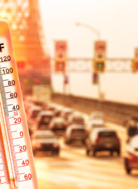 Thermometer in front of cars and traffic during heatwave