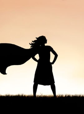 Strong Beautiful Caped Super Hero Woman Silhouette Isolated Against Sunset Sky Background