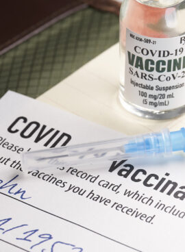 Covid-19 vaccination record card with syringe and vial