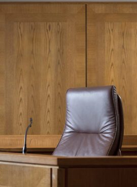 An empty courtroom bench with U S flag