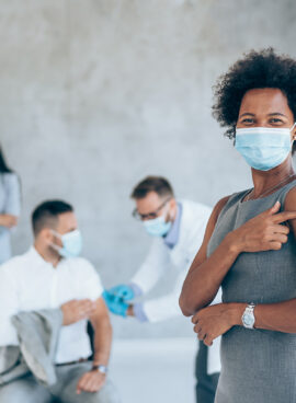 Businesswoman showing her arm after getting vaccinated in the office.