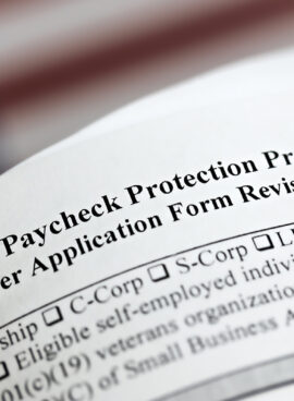 selective focus photo of paycheck protection program borrower application form revised, on a background of United States flag. paycheck protection program new round.