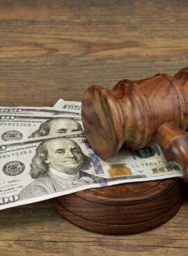 Bundle Of Money, Judges Gavel And Soundboard On Wooden Table