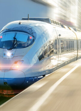 Electric passenger train drives at high speed departs from the platform.