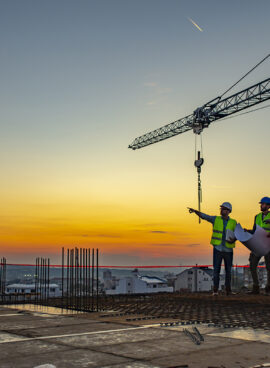 Multi ethic workers talking at construction site reviewing plans