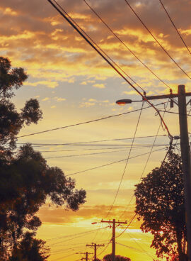 vibrant sky over silhouette of electricity lines and tree tops