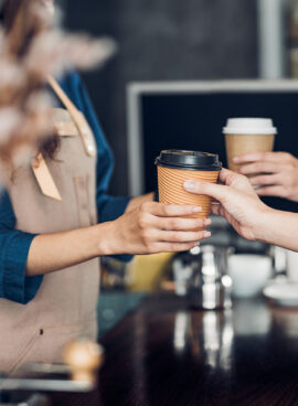 Barista served take away hot coffee cup to customer at counter bar in cafe restaurant,coffee shop business owner concept,Service mind waitress.