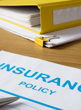 Insurance policy with pen and folder.