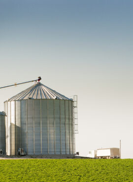 Grain Silo Bins and Truck in Farm Field Agricultural Landscape